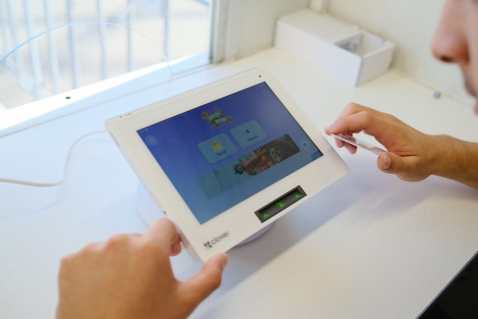 Visitor presenting a Fun Pass card at a Clover Mini terminal