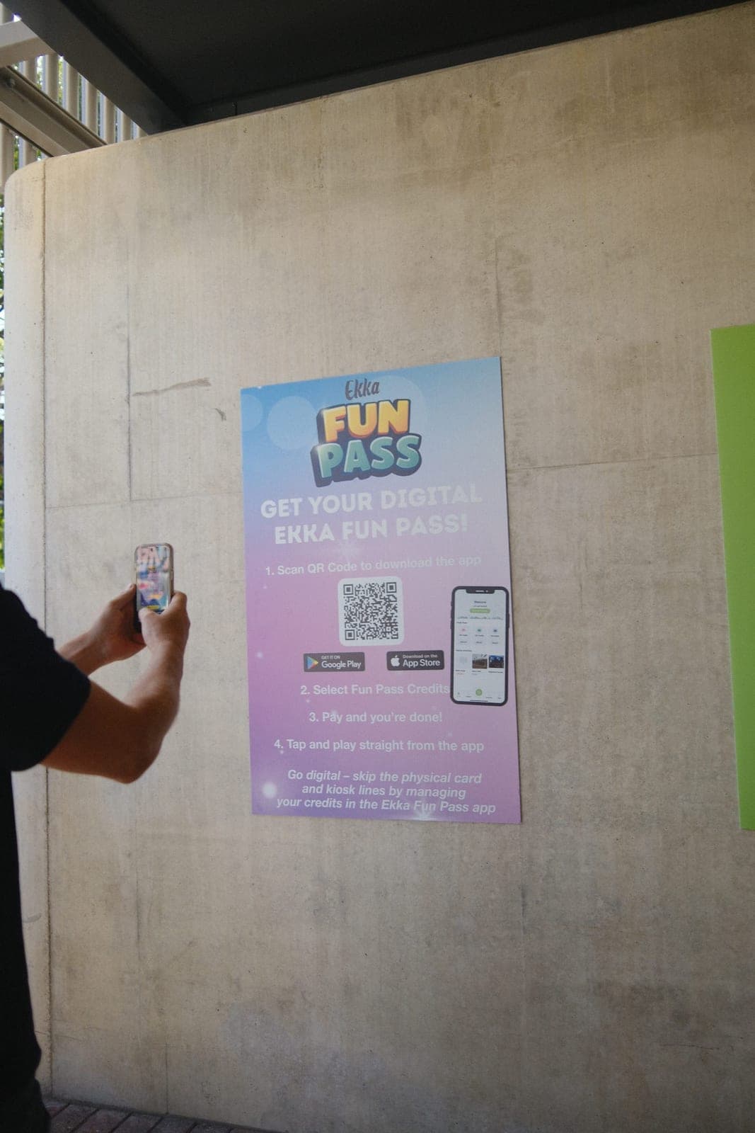 Visitor scanning QR code on Ekka Fun Pass sign to download the app