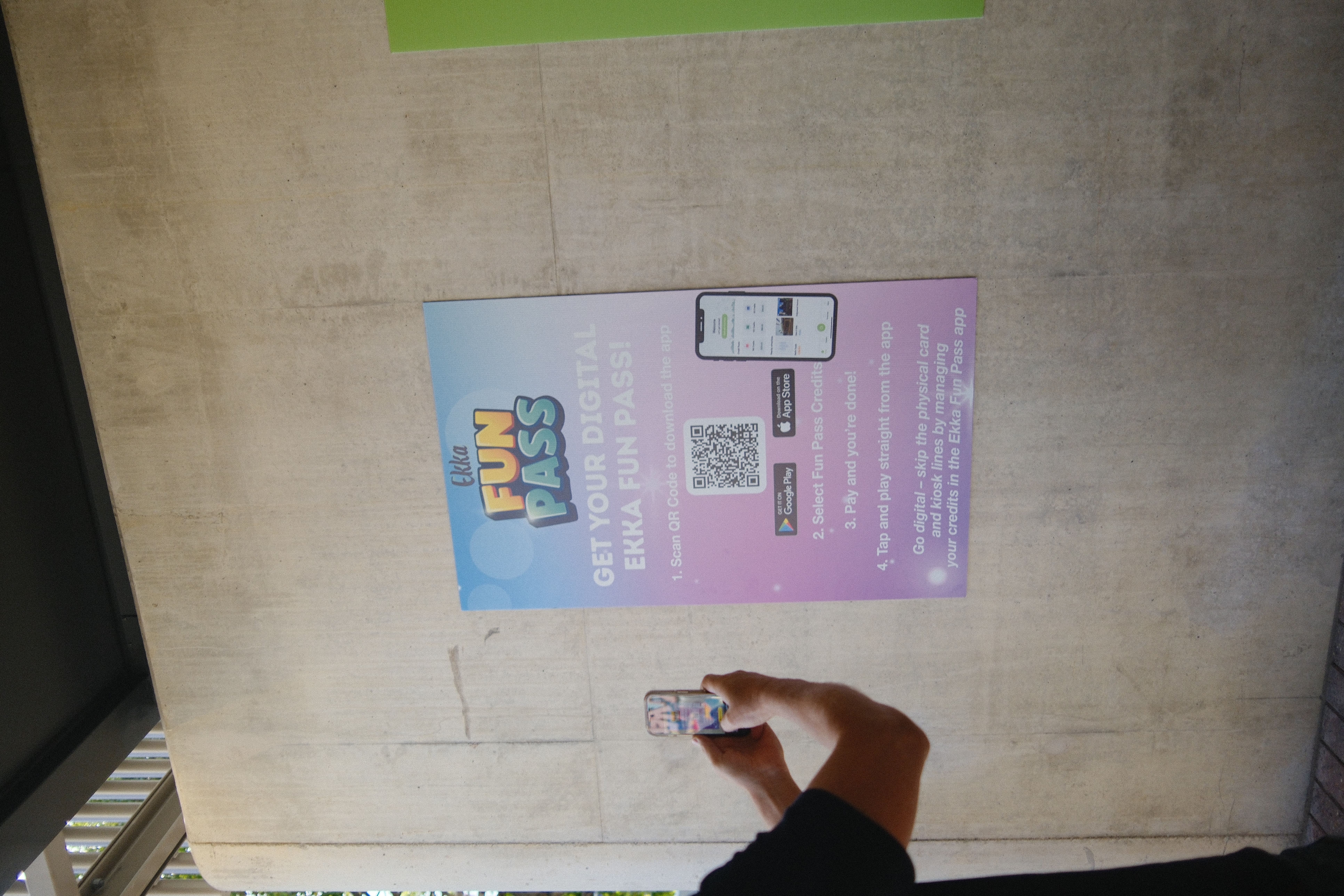 Visitor scanning QR code on Ekka Fun Pass sign to download the app