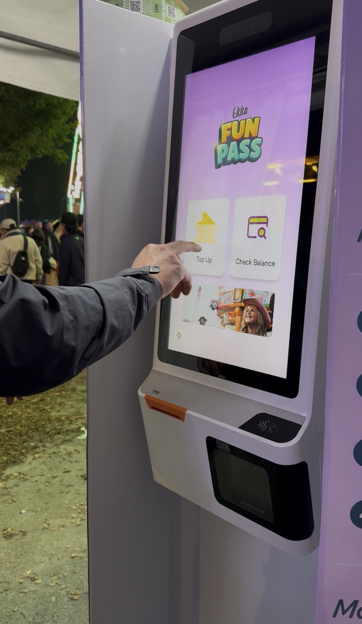 Visitor tapping Top Up on Ekka Fun Pass kiosk